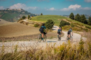Tres ciclistas con montañas detras